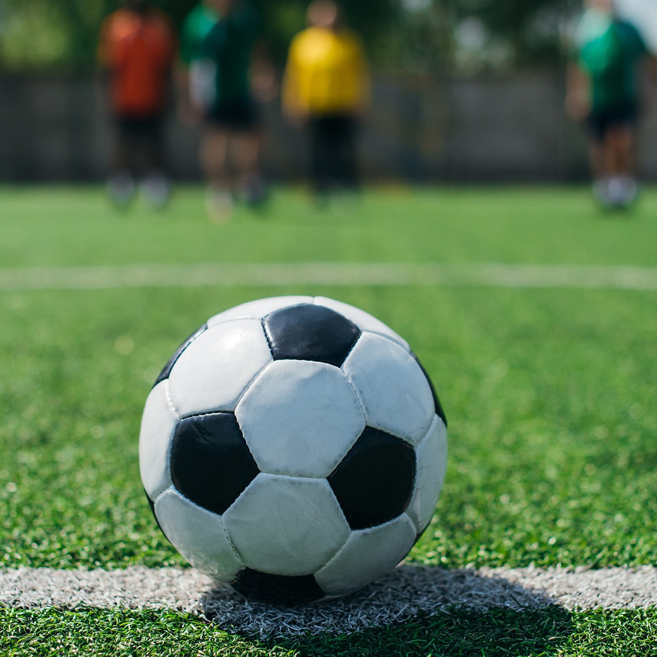 Football on the halfway line with players in the background